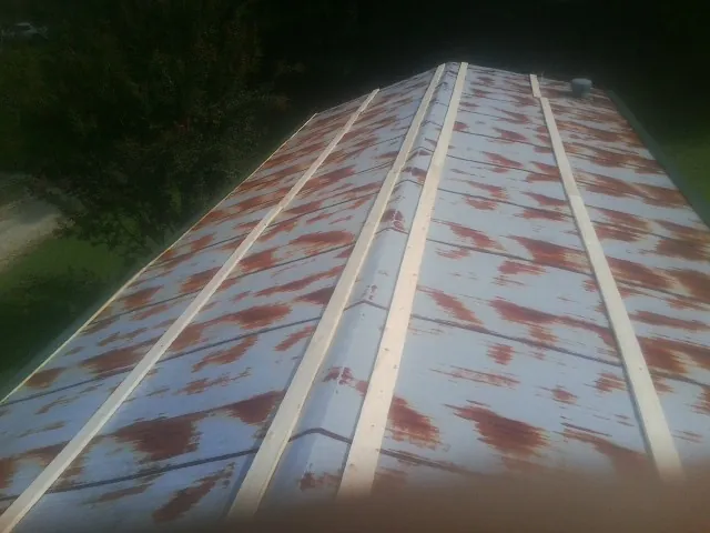 Rusted metal roof panels with new wood purlins before replacement — Storm Damage Roof Repair in Glenview by Roofing Brothers