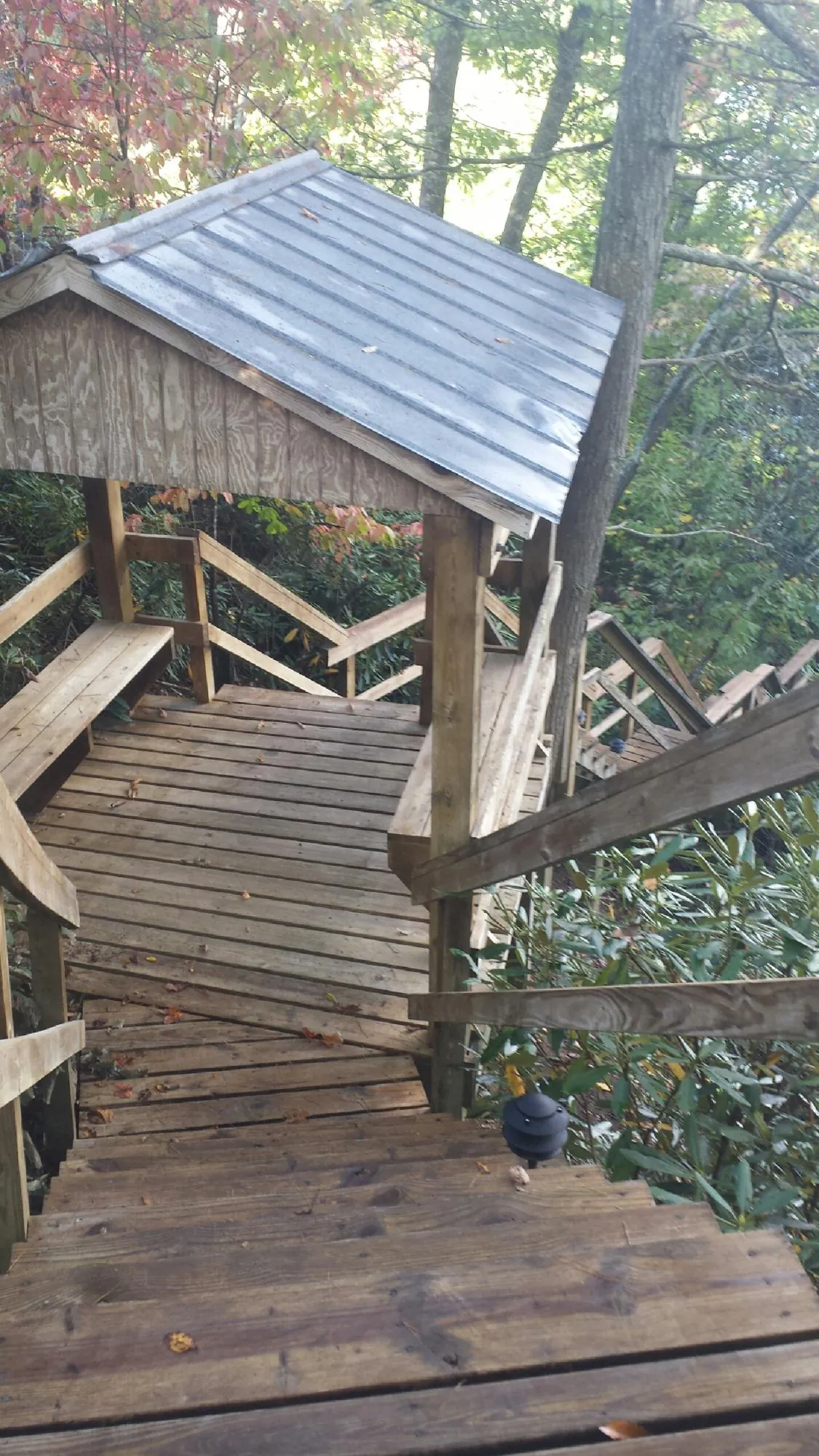 Metal roofed shelter over wooden steps on a wooded walkway — Skylight Repair & Installation work by our crew in Glenview
