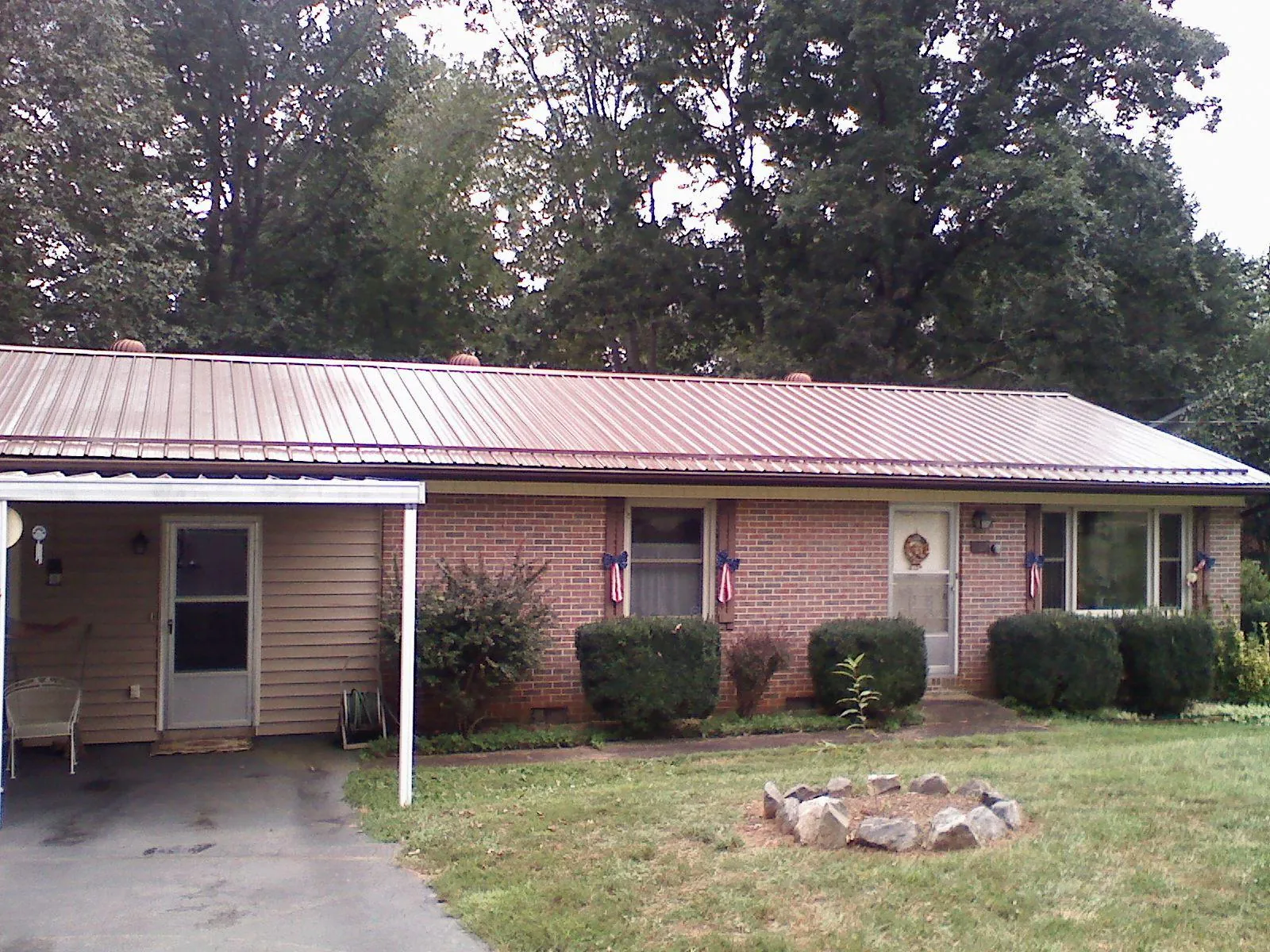 Bronze metal roof and carport on a brick ranch home — Roof Repair work by our crew in Glenview